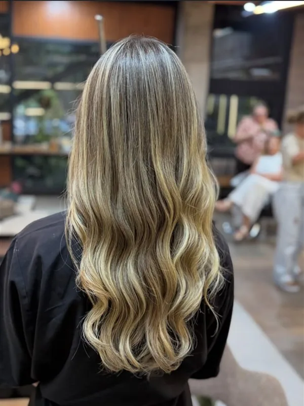Depois: loiro iluminado com mechas, fios alinhados e ondas com brilho
