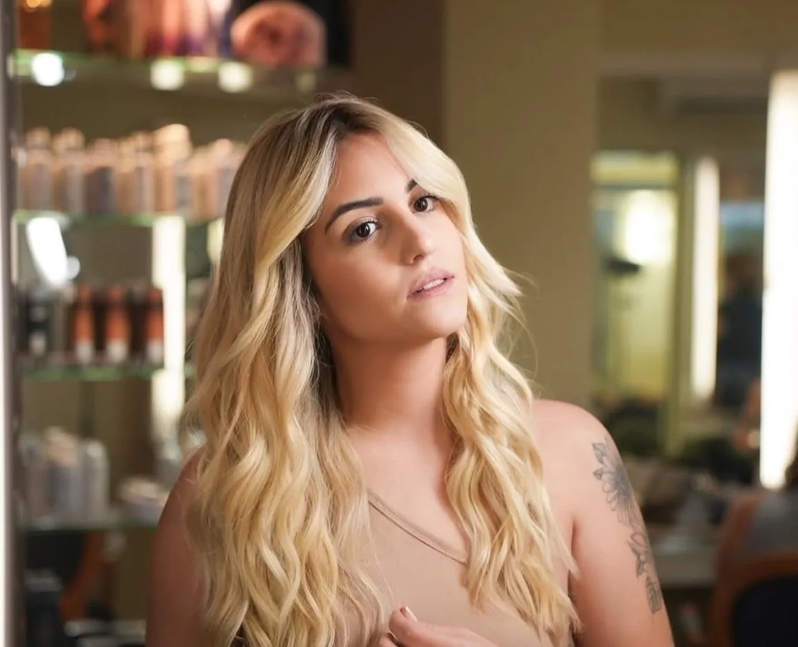 Cliente da HAAR by RUPP com loiro iluminado e ondas longas, no salão
