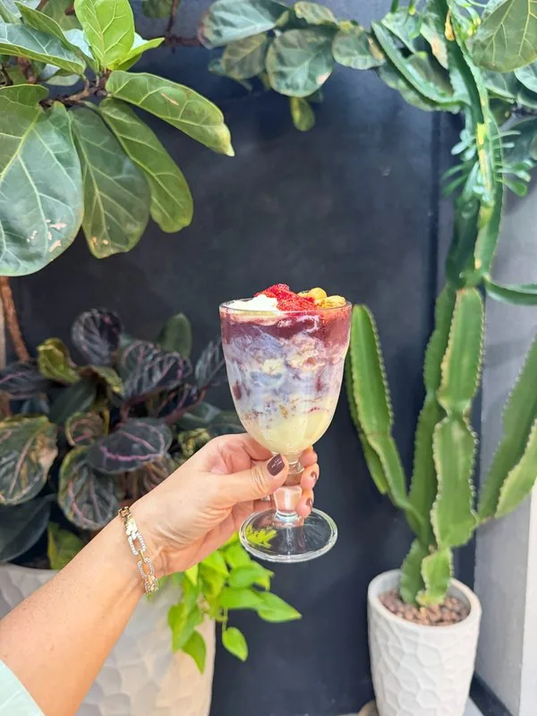 Taça de açaí com frutas servida entre as plantas do bistrô da HAAR by RUPP
