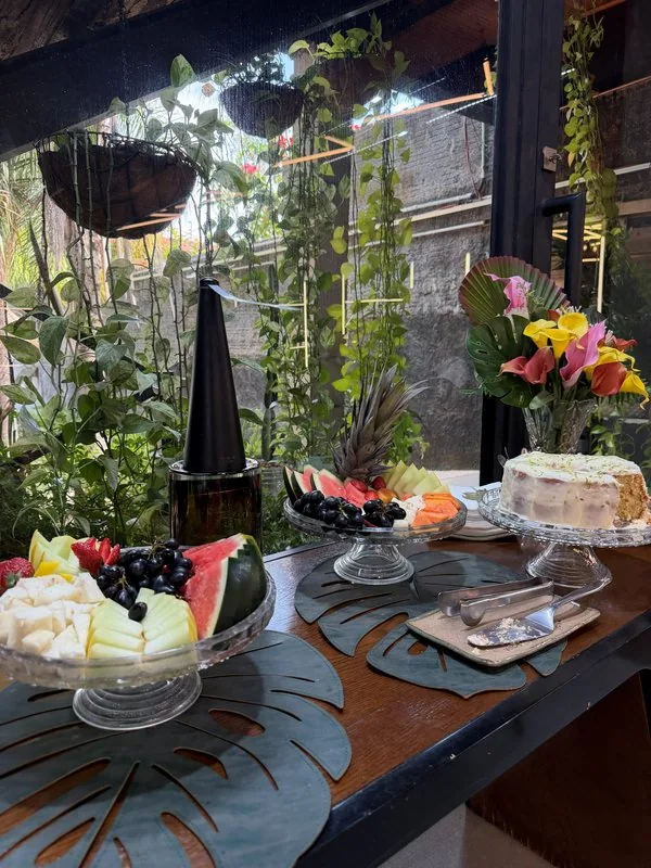 Mesa do bistrô da HAAR by RUPP com frutas, bolo e flores, no jardim do salão